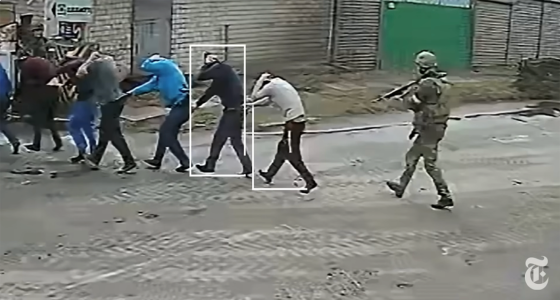 vue de plusieurs personnes menacées par un soldat armé